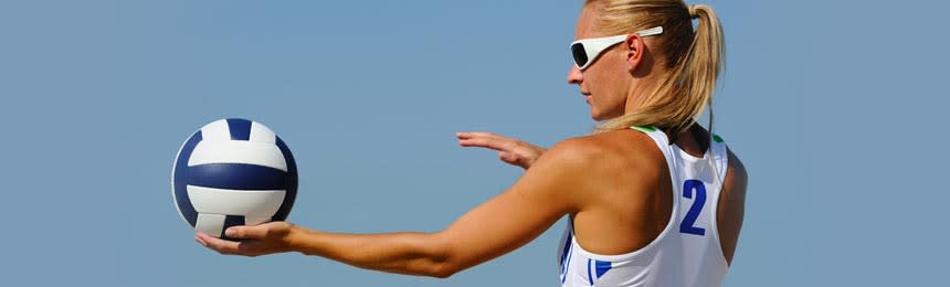 woman wearing sunglasses and playing volleyball